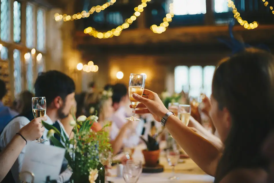 Gäste erheben bei einer festlichen Feier ihre Sektgläser zum Toast