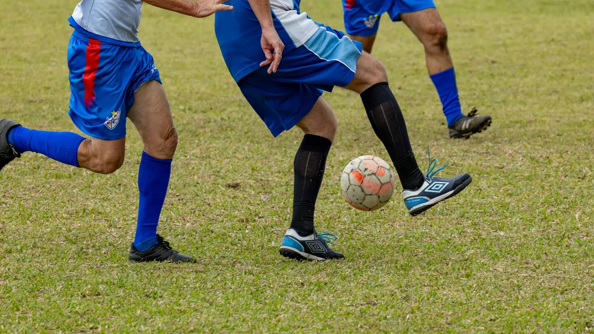 Fußballspieler üben gemeinsam mit dem Ball auf dem Rasen.