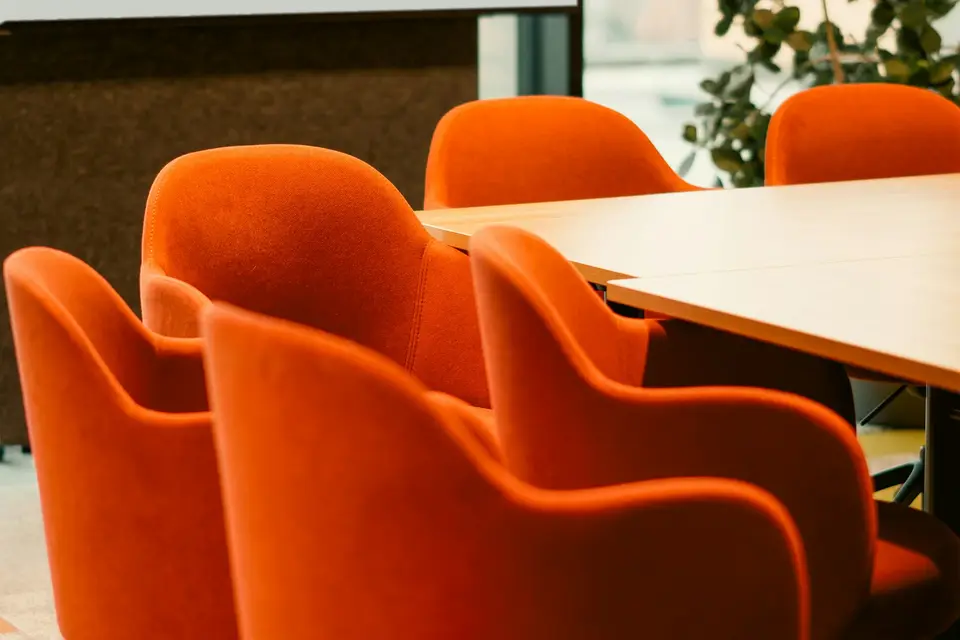 Orangefarbene Stühle um einen Konferenztisch