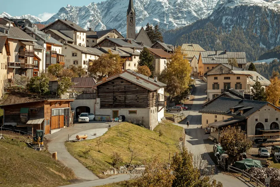 Häuser eines Dorfes vor bewaldeten Bergen