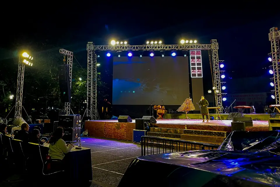 Beleuchtete Open-Air-Bühne mit Lautsprechern und Leinwand bei Nacht