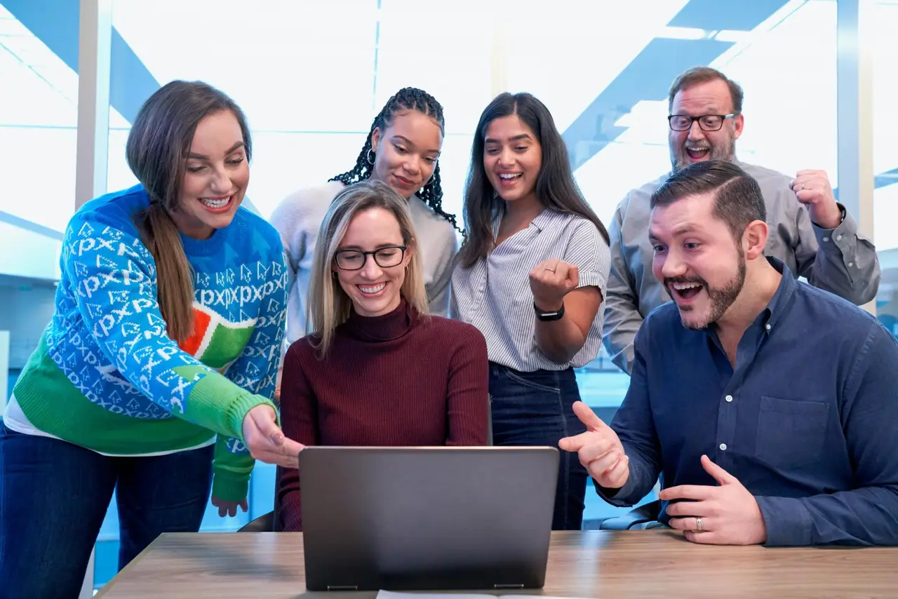 Ein Team arbeitet gemeinsam am Laptop.