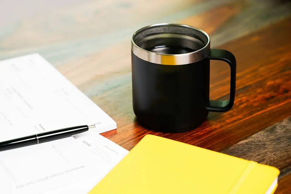 Kaffeetasse und Stift auf einem Tisch