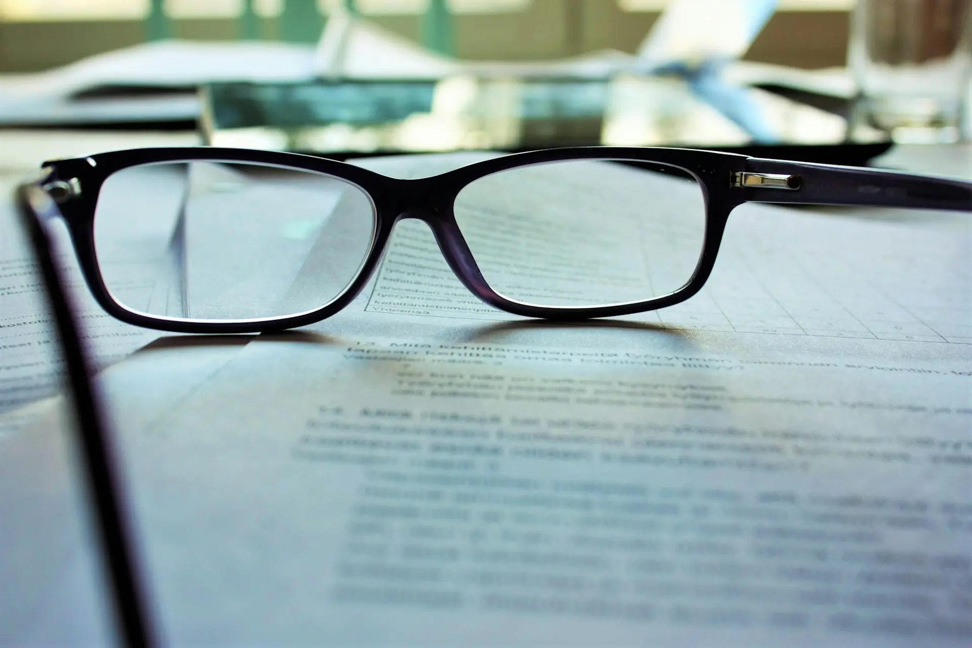 Brille liegt auf bedrucktem Papier