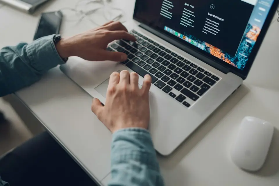 Eine Person arbeitet am Laptop an einer Website