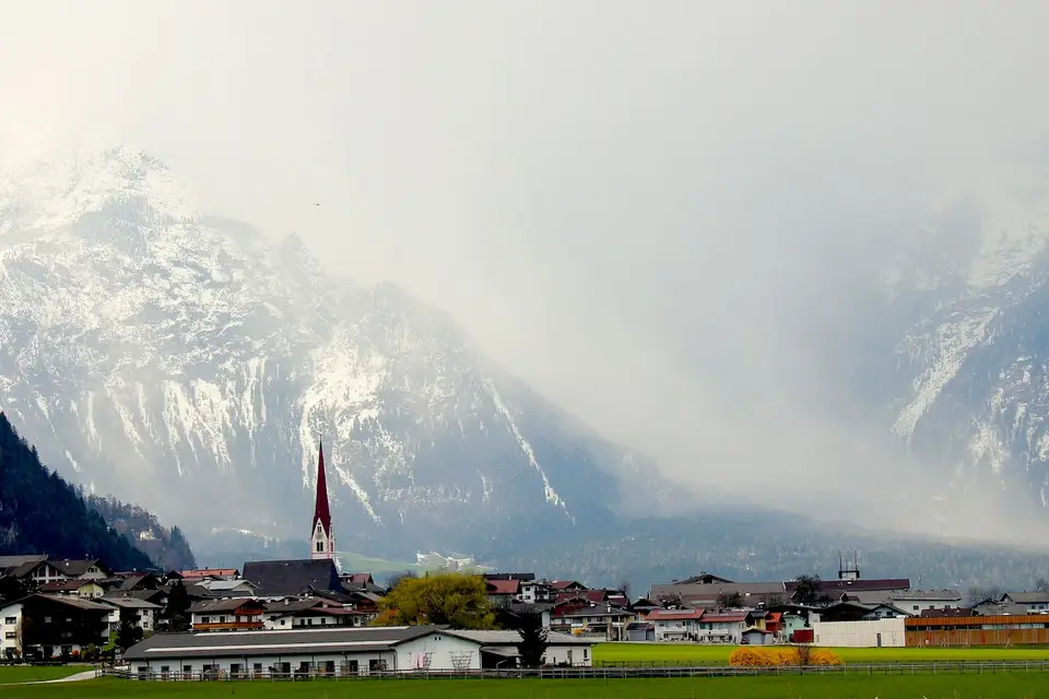 Weiße und braune Häuser vor Bergen