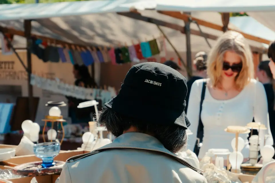 Besucherinnen und Besucher stöbern auf einem Flohmarkt im Freien