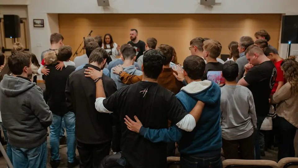 A youth group standing together arm in arm.