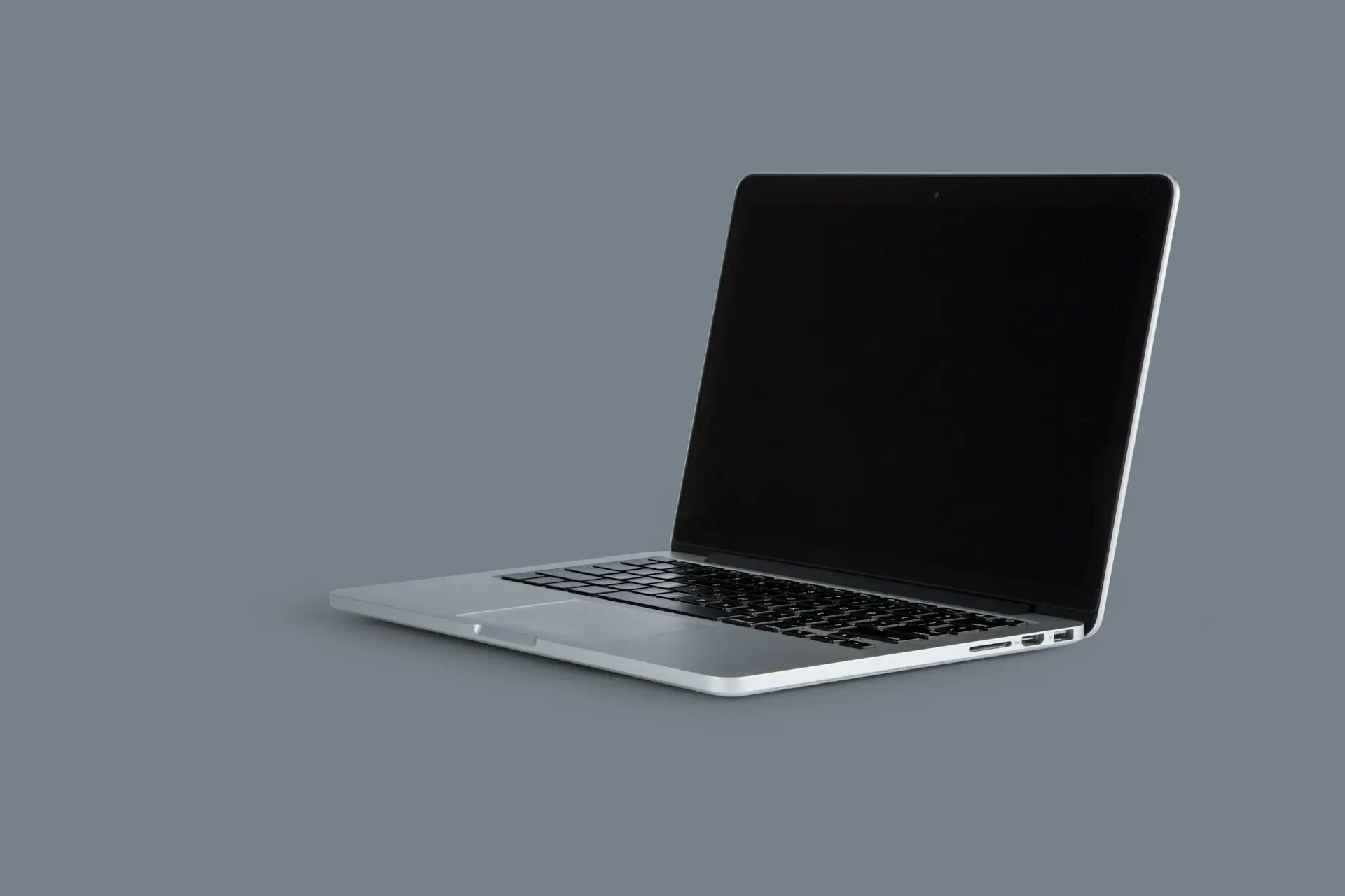 Aufgeklappter Laptop vor grauem Hintergrund